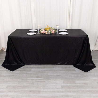 Elegant black tablecloth draped over a table with floral centerpiece and plates.