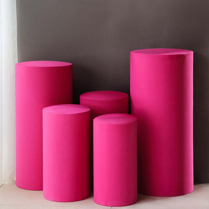 Pink display pedestals in various heights on a neutral background.