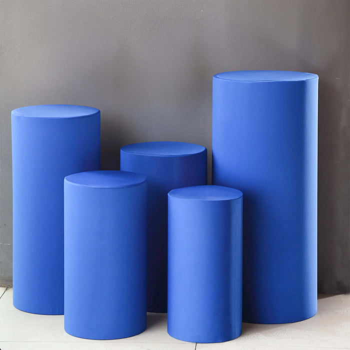 Set of five blue cylindrical pedestals in varying heights.