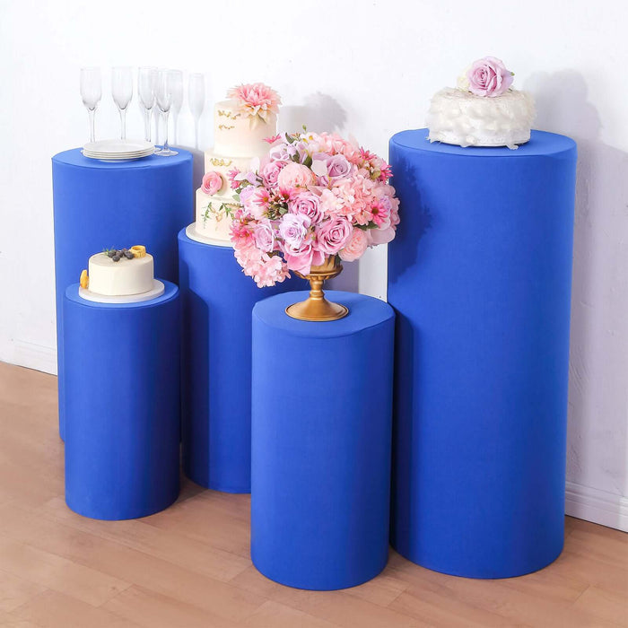 Blue display pedestals with floral arrangements, cakes, and champagne glasses.
