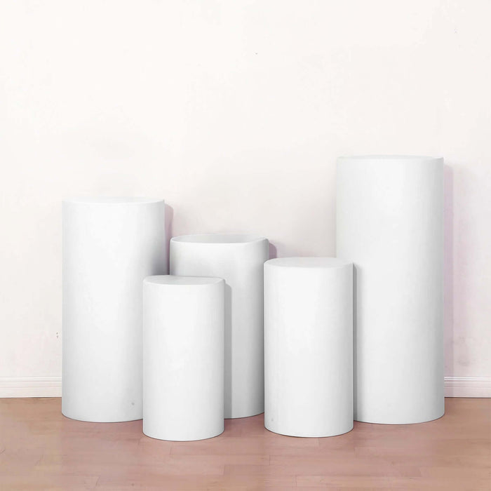 White display pedestals in various heights arranged in a studio setting.