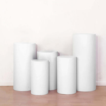 White display pedestals in various heights arranged in a studio setting.