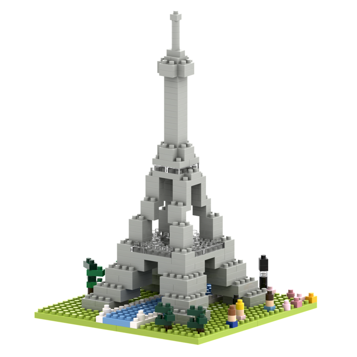 The Brixies Small Gift Box Large Eiffel Tower features a detailed micro-brick model on a green base with trees, flowers, and a river, bringing Parisian charm to any space.