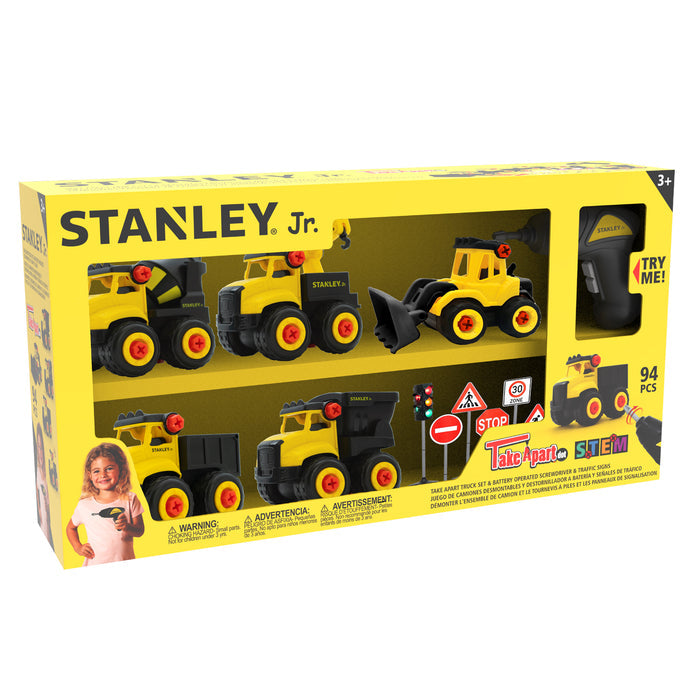 A yellow and black Red Toolbox Stanley Jr. Take Apart Dot 5 Piece Set box for ages 3+, featuring four construction vehicles, a battery-operated screwdriver, traffic signs, cones, and a smiling child holding a toy.