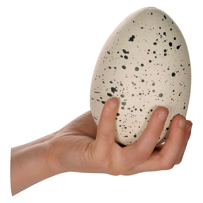 A hand holds the Toysmith Ginormous Hatchin' Grow Dino Egg with black speckles against a white backdrop—an exciting Toysmith kids’ activity or growing dinosaur toy.